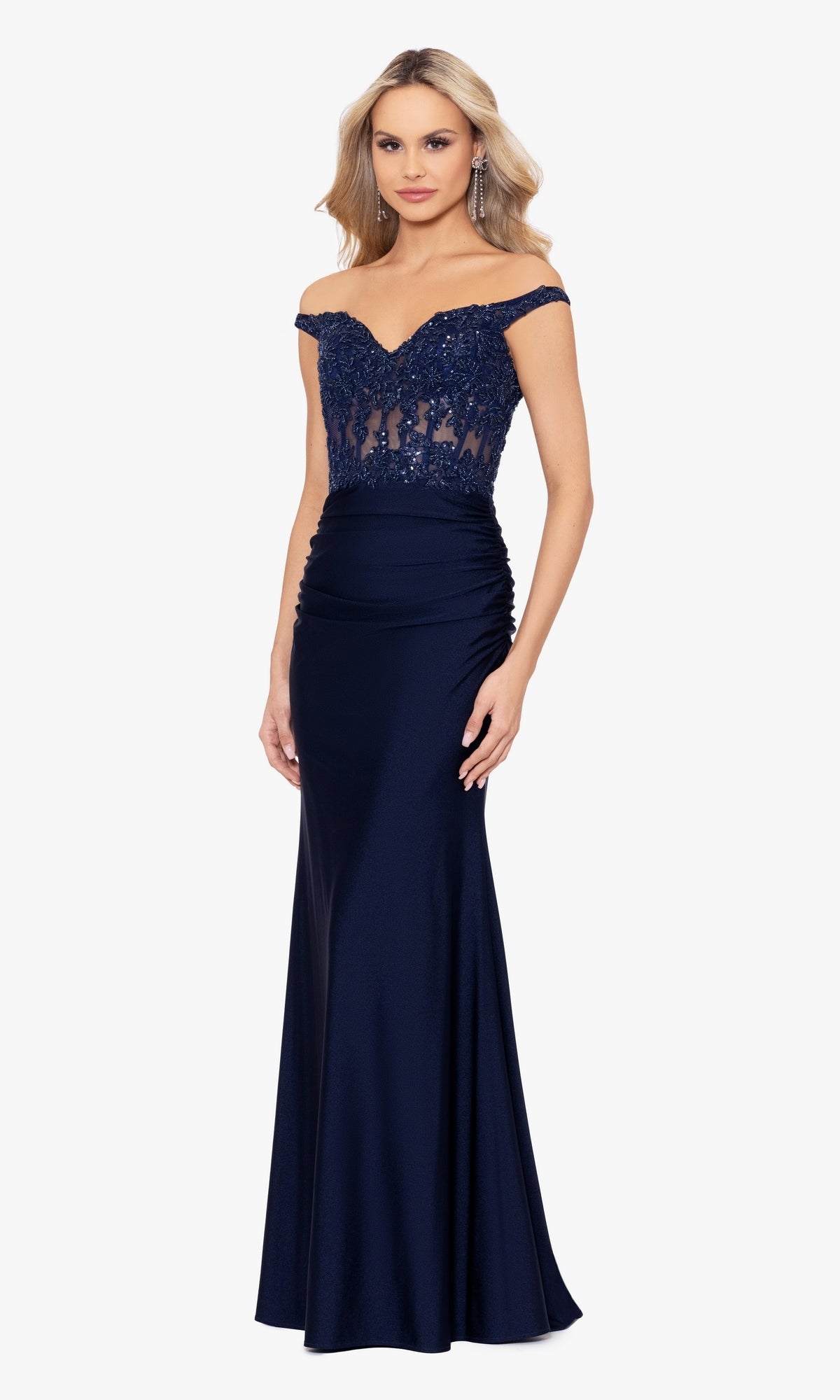 A woman stands facing forward, wearing the Off-the-Shoulder Long Navy Prom Dress A26276 with a fitted sequined bodice and a floor-length skirt.